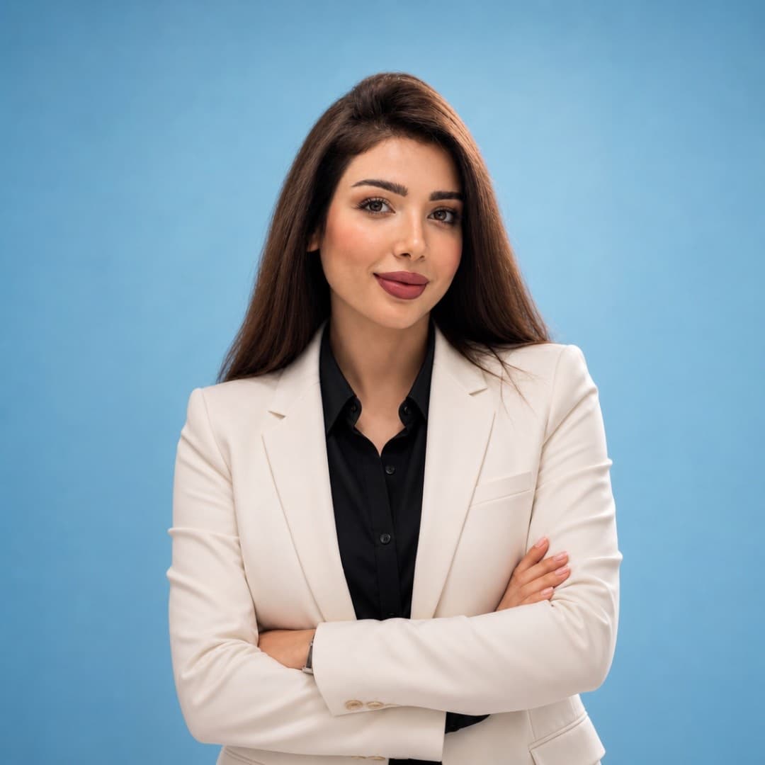 Walaa Mutar in a cream blazer, arms folded, against a blue backdrop